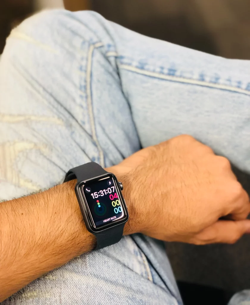 wrist with a smartwatch placed on the jeans